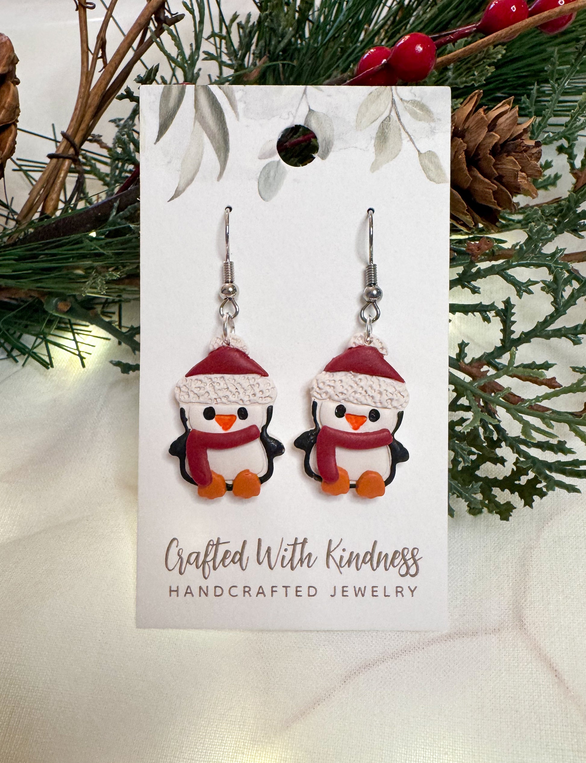 Detailed Christmas penguin earrings. Each penguin has a red winter hat and red scarf on. All made from polymer clay. 