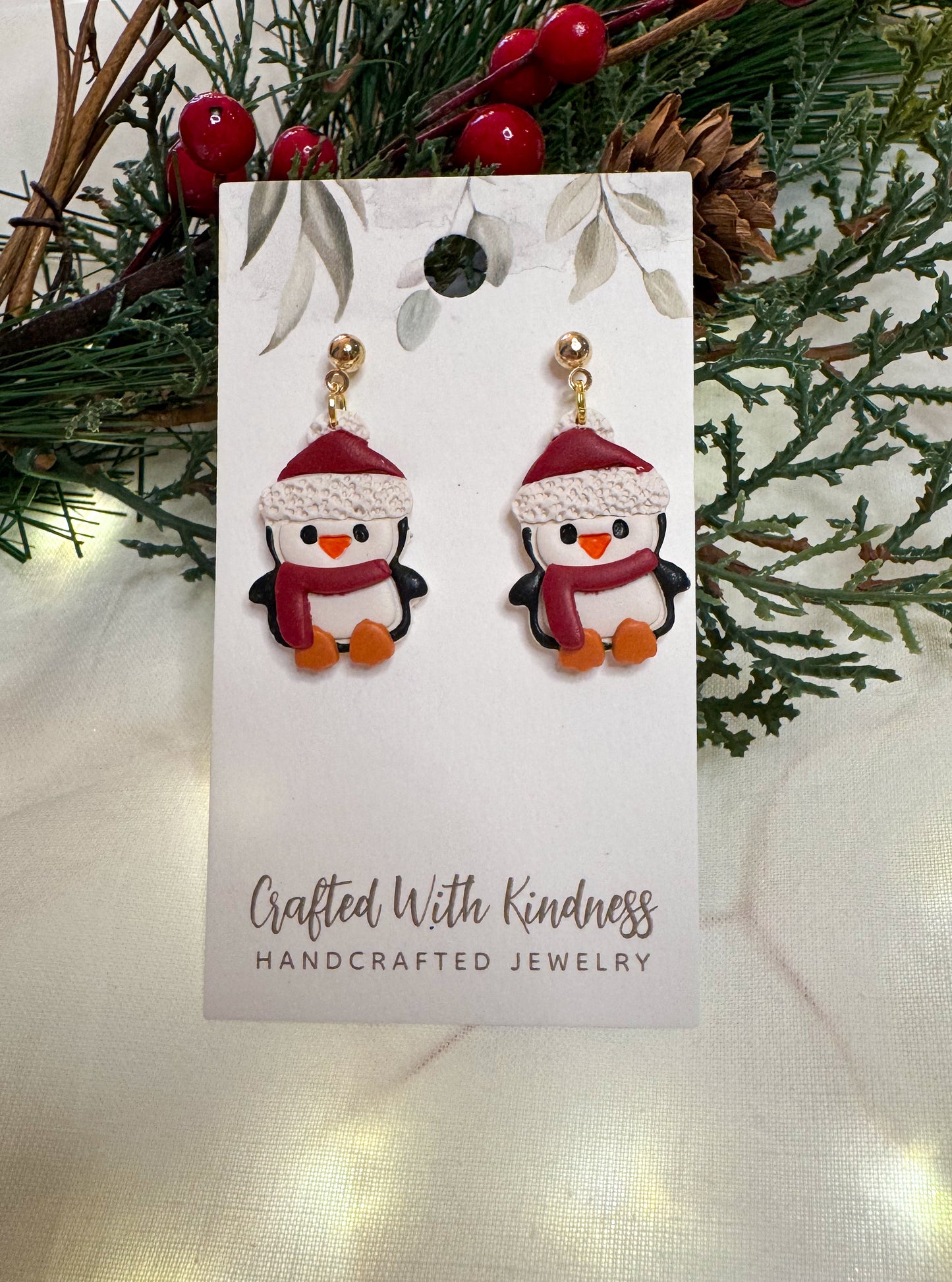 Detailed Christmas penguin earrings. Each penguin has a red winter hat and red scarf on. All made from polymer clay. 